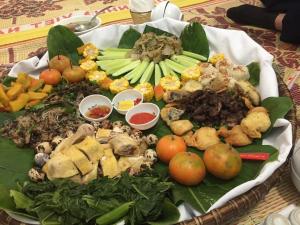 a plate with a bunch of food on a table at A Lử Homestay in Mù Cang Chải