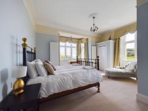 a large bedroom with a large bed and a couch at The Old Vicarage in Ilfracombe