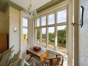 a living room with a table in front of a window at The Old Vicarage in Ilfracombe