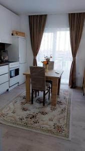 a kitchen with a table with a chair and a kitchen with a window at White Apartments in Kosovo Polje
