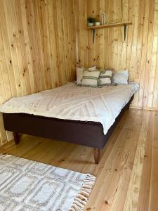 Cama en habitación con pared de madera en Metsamajake Värskas en Värska
