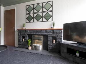 sala de estar con chimenea de piedra y TV de pantalla plana en Pass the Keys Comfortable flat en Scunthorpe