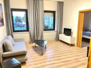 uma sala de estar com um sofá e uma televisão em Apartment in Düren em Düren - Eifel