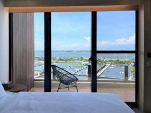 a bedroom with a bed and a view of the ocean at 緩慢大鵬灣 in Donggang