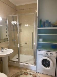 a bathroom with a shower and a washing machine at Иссык-Куль ЦО "Karven Four Seasons" таунхаус in Chon-Sary-Oy