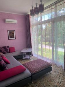 a living room with a couch and a large window at Иссык-Куль,Частный таунхаус-всего минута до пляжа в ЦО "Karven Four Seasons" Issyk-Kul in Chon-Sary-Oy +61 photos