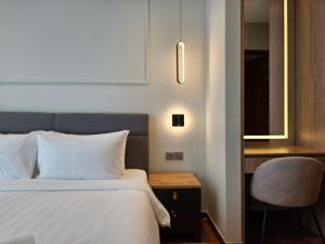 a bedroom with a bed and a desk and a chair at Sky Suites KLCC by Asiapex in Kuala Lumpur