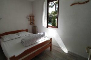 1 dormitorio con 1 cama con ventana y ventana en Entre plage et forêt - Agréable T3, en Saint-Georges-de-Didonne