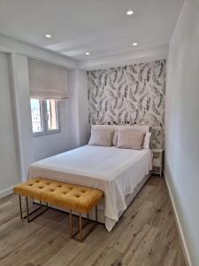 sypialnia z dużym łóżkiem i ławką obok w obiekcie PASEO MARITIMO w mieście Fuengirola