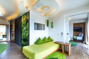 a living room with a green bed and a chandelier at Hotel Freund - Privathotels Dr Lohbeck in Oberorke