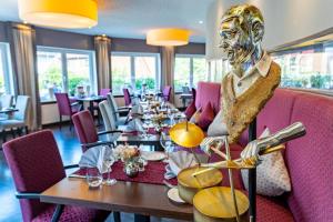 un comedor con mesas y una estatua en el medio en Hotel Freund - Privathotels Dr Lohbeck en Oberorke