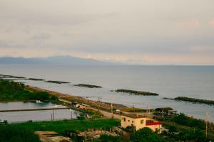 an aerial view of the ocean and a city at 緩慢大鵬灣 in Donggang