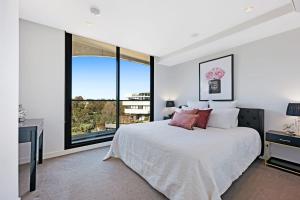 a bedroom with a large bed and a large window at Luxury overlooking the Yarra - 01663 in Melbourne
