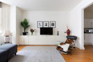 uma sala de estar com um sofá e uma televisão em Hyde Park - Knightsbridge - Private Entrance em Londres