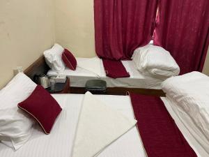 two beds in a room with red curtains at KAT RESORT PVT.LTD in Kakani