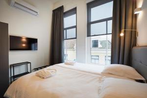 a bedroom with a bed and a large window at "DE BANK" - Hotel Apartments in Harlingen