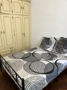 uma cama com lençóis e almofadas preto e branco em Maison - jardin aux portes de Bordeaux em Cenon