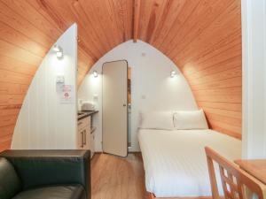 a small room with a bed and a chair at Pod No 5 in Keswick