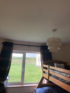 a bedroom with a window with a chandelier and a chair at Shanadune in Tralee
