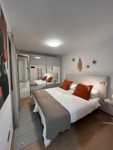 een slaapkamer met een groot bed met oranje kussens bij VV Janoa Playa Canteras in Las Palmas de Gran Canaria