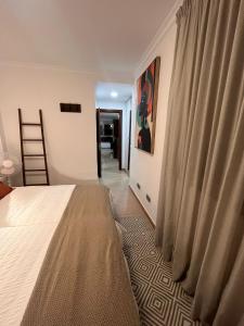 een slaapkamer met een bed en een gordijn en een hal bij VV Janoa Playa Canteras in Las Palmas de Gran Canaria