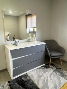 ein Badezimmer mit einem Waschbecken, einem Spiegel und einem Stuhl in der Unterkunft Casa da Portela in Paredes de Coura + 20 Fotos