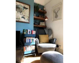 a living room with a chair and a book shelf at Bright, book-filled flat in artsy Stokes Croft in Bristol