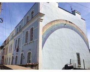 a building with a rainbow painted on the side of it at Bright, book-filled flat in artsy Stokes Croft in Bristol