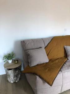 a couch with a blanket on it with a table at Appartement le quartier haut in Sète