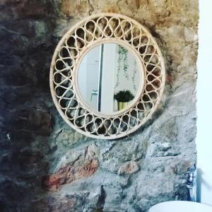 a mirror on a stone wall in a bathroom at Appartement le quartier haut in Sète