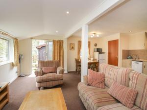 - un salon avec un canapé, des chaises et une table dans l'établissement Beech Timber Lodge, à Keswick