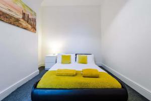 a bedroom with a bed with yellow cushions on it at Anfield House in Liverpool