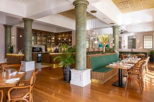 een restaurant met tafels en stoelen en een bar bij Hemingways Nairobi in Nairobi