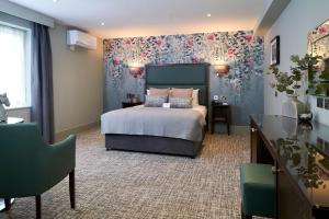 um quarto com uma cama com papel de parede floral em Mandolay Hotel Guildford em Guildford