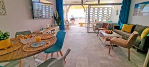 un soggiorno con tavolo, sedie e divano di Ferienwohnung Vista Faro in Morro Jable a Morro del Jable