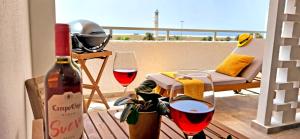 una bottiglia di vino e due bicchieri sul balcone di Ferienwohnung Vista Faro in Morro Jable a Morro del Jable