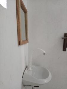 a white toilet in a bathroom with a window at Bwejuu Garden View Bungalows in Kiganga