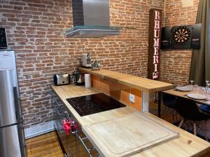 a kitchen with a counter and a brick wall at L'Étage, hypercentre Toulousain, Climatisé in Toulouse