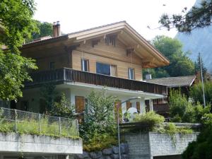 een houten huis met een hek ervoor bij Apartment Chalet Holzwurm-1 by Interhome in Grindelwald +12 foto's