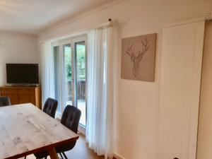 a dining room with a wooden table and a window at Apartment La Riva by Interhome in Laax