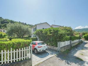 ein Auto, das in einer Einfahrt neben einem Zaun parkt in der Unterkunft Holiday Home Lucerna Due-1 by Interhome in Ameglia