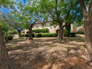 a large yard with trees in front of a building at Holiday Home Mas Mont Plaisir by Interhome in Gallician