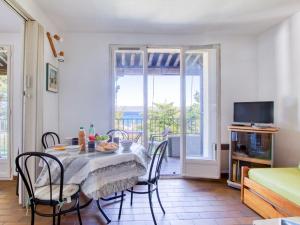 uma sala de jantar com uma mesa e cadeiras e uma televisão em Apartment Les Aigues Marines-12 by Interhome em La Madrague