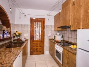 kuchnia z drewnianymi szafkami i drewnianymi drzwiami w obiekcie Holiday Home Andrea by Interhome w mieście Balcon del Mar