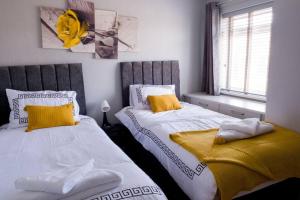 twee bedden naast elkaar in een slaapkamer bij Cosy Luxurious 3-Bedroom Home in Birmingham