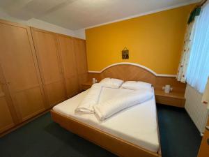 ein kleines Schlafzimmer mit einem weißen Bett mit gelben Wänden in der Unterkunft Apartment Kathrein - ISL505 by Interhome in Ischgl
