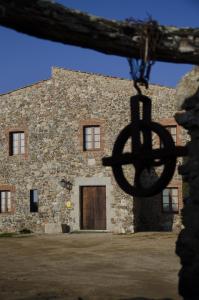 ein großes Steingebäude mit einer Tür davor in der Unterkunft Mas Valentí 1511 in Vall-llobrega