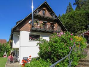 a house with a balcony and flowers at Apartment Haus Ganter by Interhome in Hinterzarten
