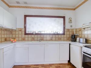 a kitchen with white cabinets and a window at Apartment La Caterina-1 by Interhome in Les Lecques +15 photos
