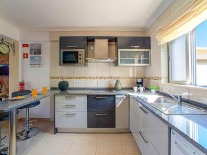 cocina con armarios blancos y encimera en Apartment Bela Vista - PMO130 by Interhome en Lagoa